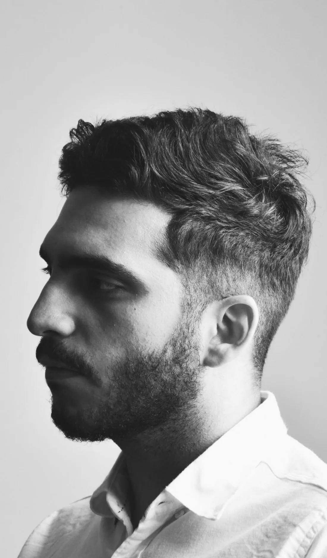 Retrato de perfil de un hombre con cabello abundante y natural